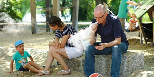 a man and a woman sitting on a rock with a dog